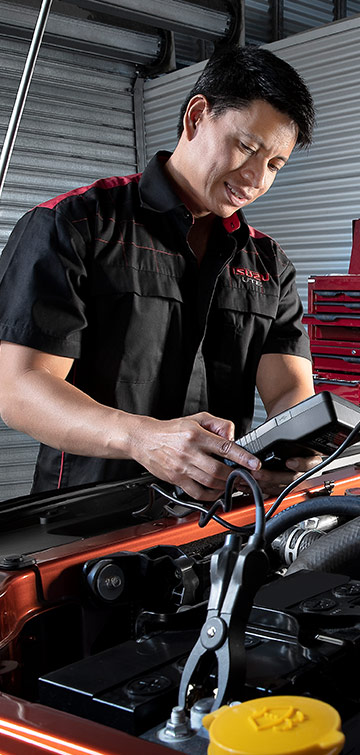 Two Isuzu Ute Service Plus technicians service the engine of an Isuzu Ute